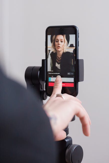 A woman recording a vertical video on her smartphone, focusing on engaging digital content creation.
